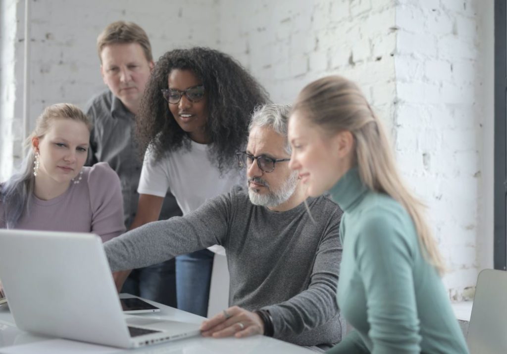 cheerful diverse colleagues working on laptop in office 3860813 2